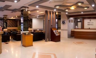 a modern hotel lobby with a check - in desk , couches , and other furniture , as well as a reception area at Griya Hotel
