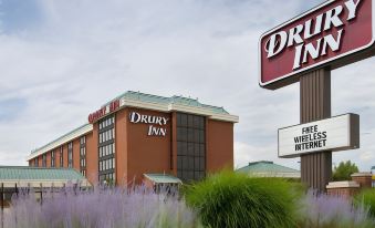 "a large building with a sign that reads "" drury inn "" prominently displayed on the front" at Drury Inn & Suites St. Louis Airport