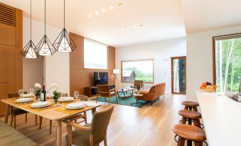 a dining room with a wooden table and chairs , surrounded by chairs and a couch at Birchwood Chalet