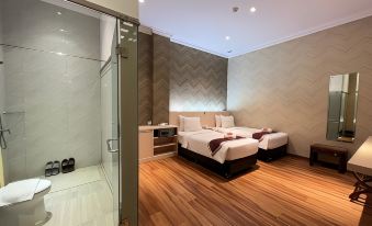 a hotel room with two beds , a glass door separating the bathroom from the rest of the room at Grand Singgie Hotel
