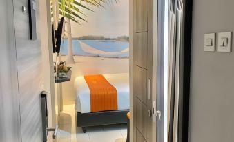 a bedroom with a bed , a lamp , and a view of a beach through the door at Front One Boutique Karawang