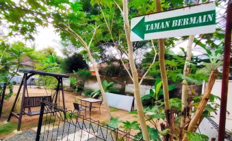 a sign for taman berma , a popular outdoor food and drink establishment , with a view of a river and greenery beyond at Bakom Inn Syariah