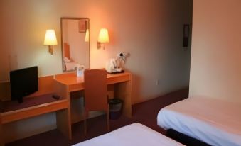 a hotel room with two beds , a desk , and a tv , all neatly arranged in the space at Days Inn by Wyndham Taunton
