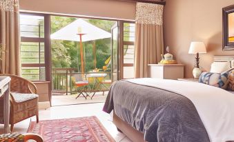 a cozy bedroom with a bed , curtains , and an open door leading to a patio area at Upper House Guesthouse