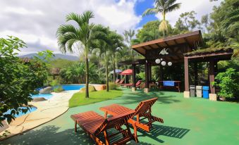 a backyard with a pool , a hot tub , and a patio area surrounded by greenery at Hotel Mountain Paradise
