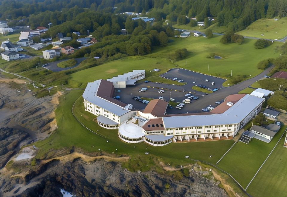 an aerial view of a large building with multiple floors and a parking lot surrounded by trees at Adobe Resort