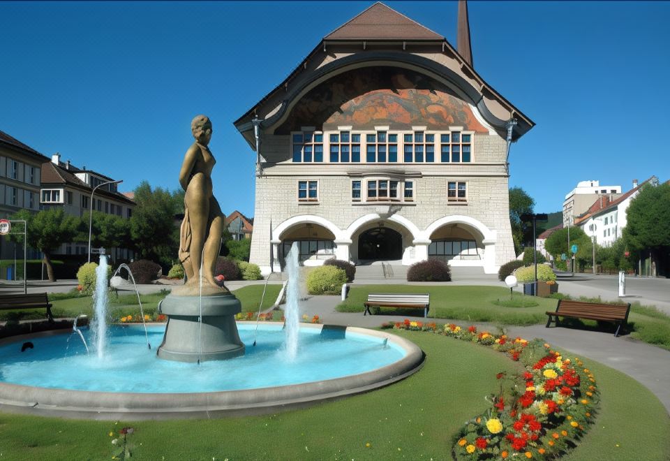 a large building with a fountain in front of it , surrounded by lush greenery and flowers at Fleur de LIS