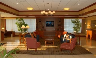 a large living room with multiple couches and chairs arranged around a coffee table , creating a cozy atmosphere at Wyndham Garden Manassas