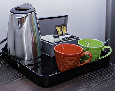 a dining table with a tray containing two mugs , a kettle , and a coffee maker at Village Hotel Liverpool