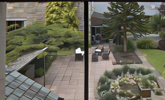 a balcony overlooking a lush green garden , with several chairs and tables placed around the area at Stanley Lodge Farmhouse