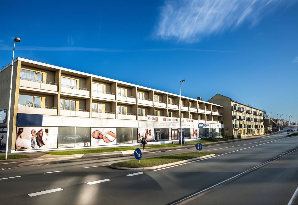 a modern , white building with balconies and large windows , situated in an urban environment with clear blue skies and traffic light , under a at Hotel-B