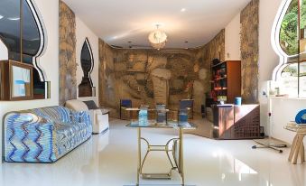 a modern living room with a blue couch , coffee table , and two chairs in front of a wall mural at Hotel Paraiso Encantado