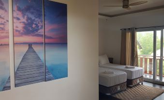 a room with two beds and a large picture of a dock on the wall at Scent of Green Papaya
