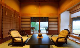 a room with wooden walls and a sliding glass door leading to a balcony overlooking a pool at Shouen