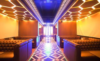 a dimly lit room with blue and white tiles on the floor , several couches lined up against the walls , and a wooden ceiling at Hotel Valentino