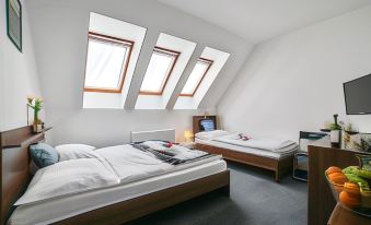 a modern bedroom with two beds , white bedding , and wooden furniture , including a desk and nightstand at Vincent