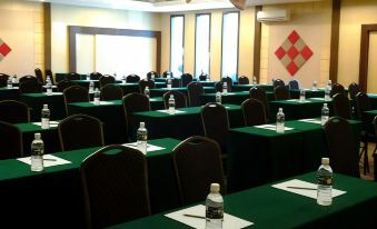 A spacious room is set up with green chairs and tables for an event or function at Golden Hotel