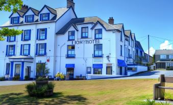 "a large white building with a blue roof and the name "" the royal hotel "" written in white letters on it" at Lion Hotel & Studio Apartments