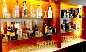 "a well - stocked bar with various bottles and glasses , including some labeled "" vodka "" and "" gin ,"" on display" at That Phanom River View Hotel