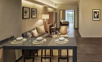 a dining area with a table set for four people , featuring wine glasses and plates on the table at Tropics Eight Suites