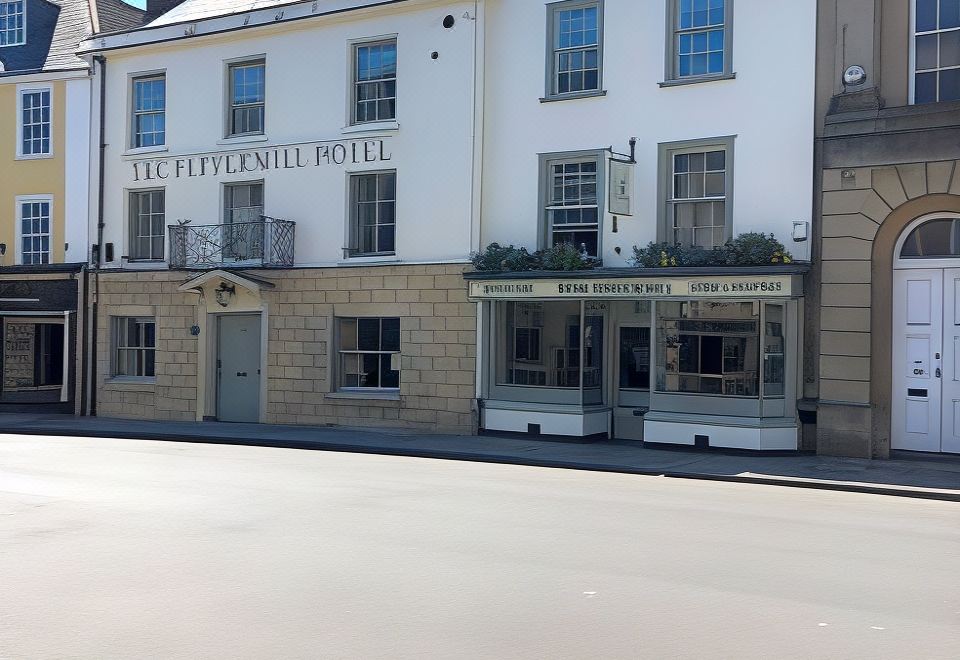 "a white building with a sign that reads "" the tiverton hotel "" is located on a street" at The Peppermill Town House Hotel & Restaurant