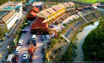 aerial view of a row of yellow and brown buildings , with cars parked in front at Doan Gia Resort Phong Nha