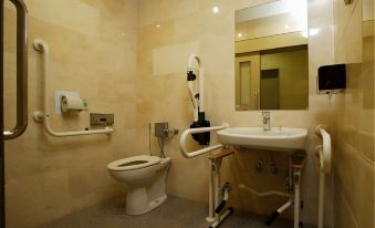 a bathroom with a toilet , sink , and shower is shown with exposed pipes and fixtures at Hamamatsu Hotel