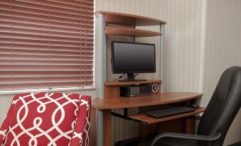 a computer desk with a monitor , keyboard , and mouse is set up in a room at Country Inn & Suites by Radisson, Fairview Heights, IL