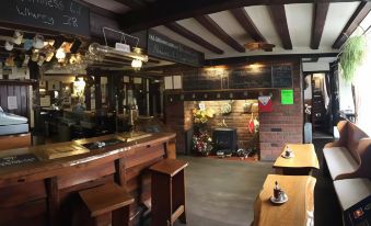 a cozy pub interior with wooden furniture , black chalkboards on the walls , and various decorations at Sorrel Horse Inn