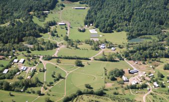 a bird 's eye view of a rural area with green fields , buildings , and roads surrounded by trees at Graves Mountain Farm & Lodges