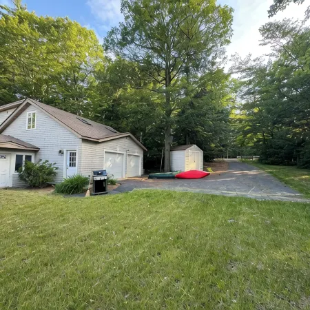 Stunning lakefront home with a boathouse, private dock, firepit and lake views