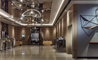 a modern hotel lobby with a large chandelier hanging from the ceiling , creating an elegant and stylish atmosphere at Front One Boutique Karawang