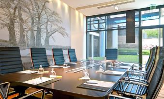 a conference room with a large table , chairs , and a mural of trees on the wall at Radisson Blu Hotel, Dakar Sea Plaza