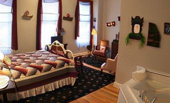 a cozy bedroom with a large bed , a rug on the floor , and various decorative items at Cornerstone Inn