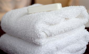 a close - up view of a white towel on a bed , with a bar of soap nearby at Homewood Suites by Hilton Aliso Viejo Laguna Beach