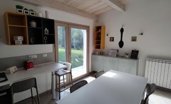 a modern kitchen with white cabinets , a large window , and a dining table with chairs at Memento