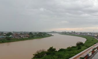 a body of water , possibly a river or a lake , surrounded by a city with a cloudy sky at Chaisaeng Palace Hotel