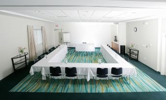 a conference room set up for a meeting , with multiple tables and chairs arranged in a circle at SpringHill Suites Detroit Auburn Hills