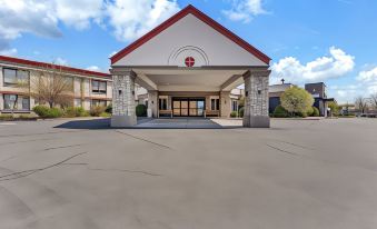 a large building with a red roof and white walls is shown in the image at Buffalo Airport Hotel