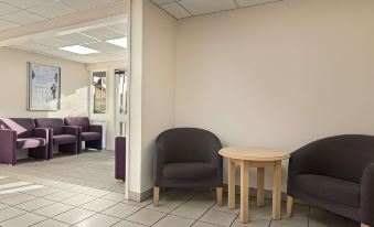 a room with two chairs and a small table in front of a wall with a doorway at Days Inn by Wyndham Sutton Scotney South