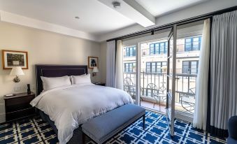 a hotel room with a large bed and a sliding glass door leading to a balcony at El Prado