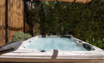 a hot tub with a wooden deck and trees in the background , creating a serene outdoor setting at Country Home