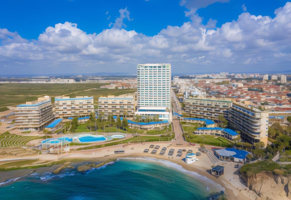 aerial view of a large resort with multiple buildings , a beach , and a body of water at Resort Hadera by Jacob Hotels