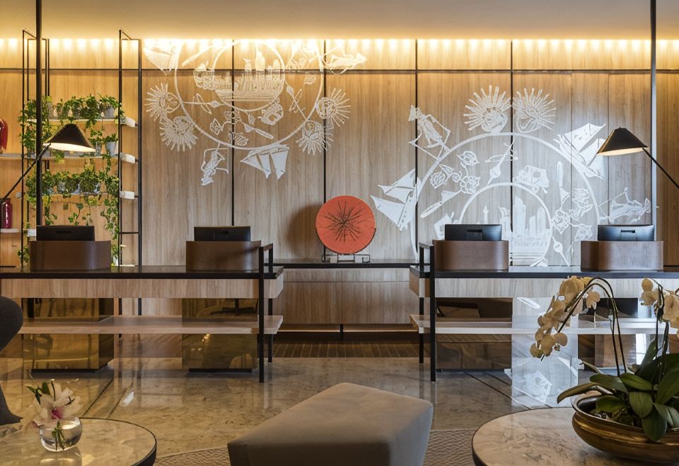a modern hotel lobby with two reception desks and a large umbrella , creating a cozy atmosphere at Swissôtel Jakarta PIK Avenue