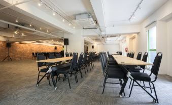a large conference room with several rows of black chairs arranged in front of a long table at Z Hotel Johor Bahru