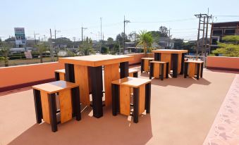 a rooftop patio with multiple tables and chairs arranged for outdoor dining , providing a pleasant atmosphere for patrons at Thatphanom View Hotel