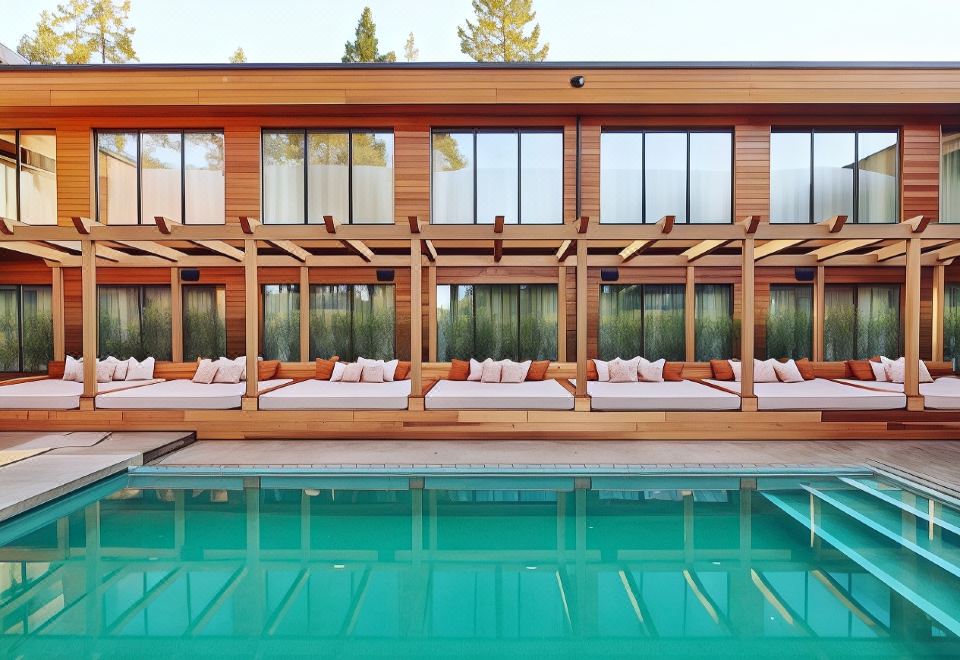 a wooden house with a pool and several lounge chairs around it , creating a relaxing atmosphere at Ellery Beach House