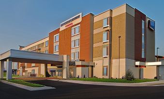 a large hotel building with a red and white striped sign on the front at SpringHill Suites Grand Forks