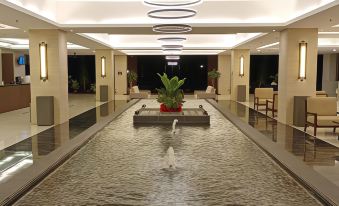 a long , empty indoor pool with a water feature in the center , surrounded by white walls at Amverton Heritage Resort