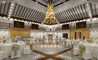 a large , elegant ballroom with multiple dining tables set up for a formal event or wedding reception at Royal Palms Beach Hotel
